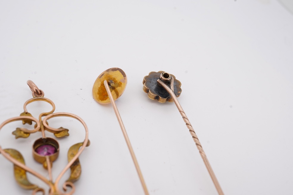 An Edwardian 15ct, diamond and seed pearl cluster set stick pin, 54mm, a similar yellow metal and cabochon garnet set stick pin and an Edwardian 9ct and gem set drop pendant. Condition - poor to fair